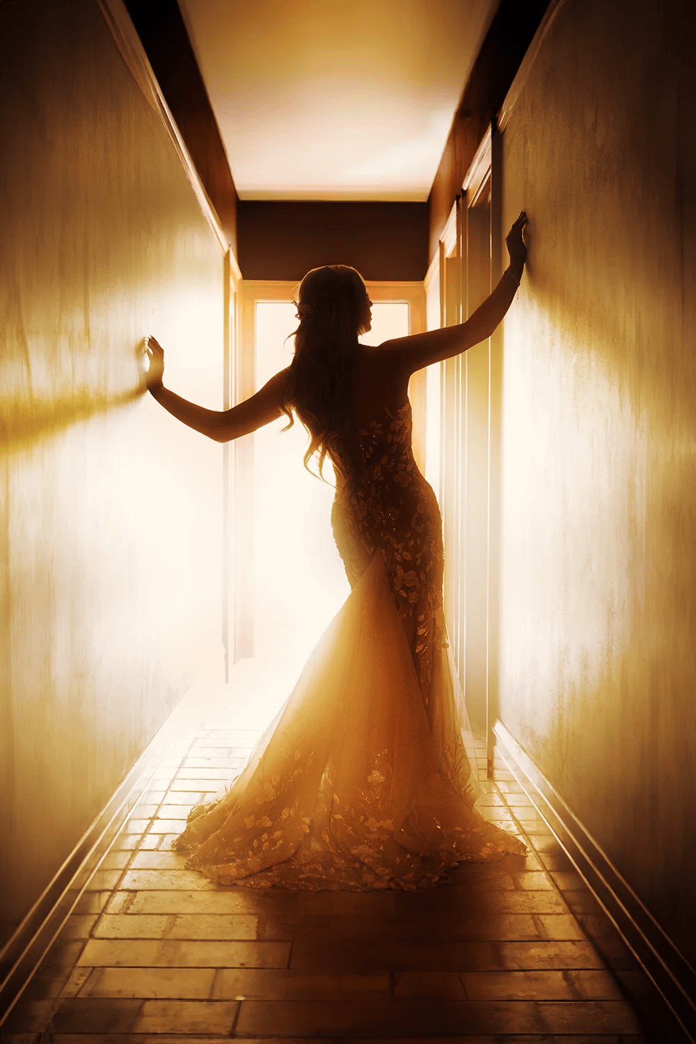 Dramatic backlit bridal portrait of a bride silhouette in a doorway with golden light