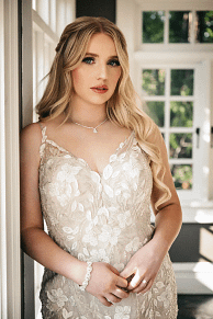 Bridal portrait of a bride in a spaghetti strap lace wedding dress with delicate jewelry
