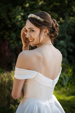 Classic bridal portrait of smiling bride looking over her shoulder with an elegant hairstyle and veil