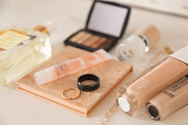Flat lay of bridal makeup products perfume bottles and wedding jewelry