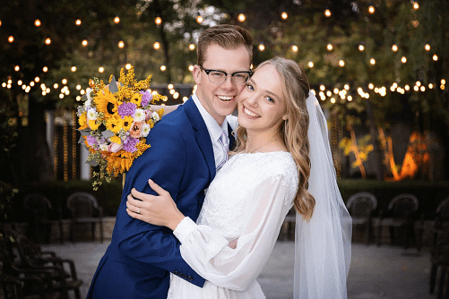 Smiling bride and groom sitting together at wedding reception
