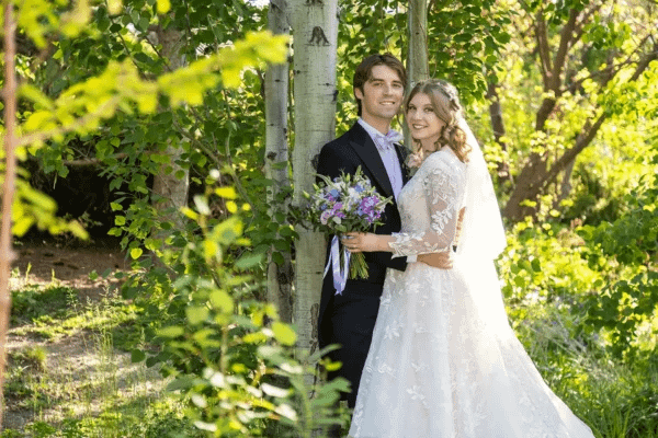 Bride holding colorful summer wedding floral bouquet outdoors