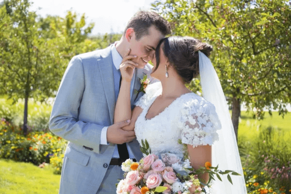 Romantic candid moment of bride and groom kissing outdoors